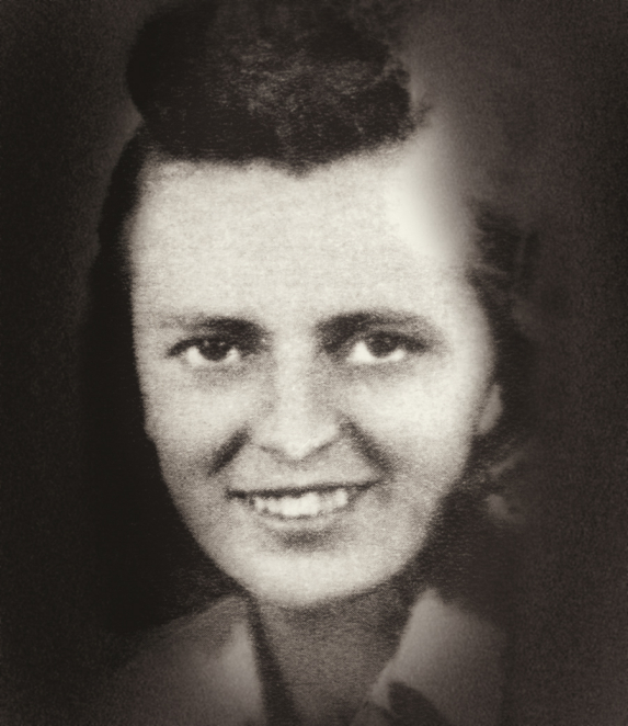 A black-and-white portrait photograph of a young woman, taken from close up. She has dark, neatly combed hair and is looking directly at the camera. The background is light and devoid of detail.