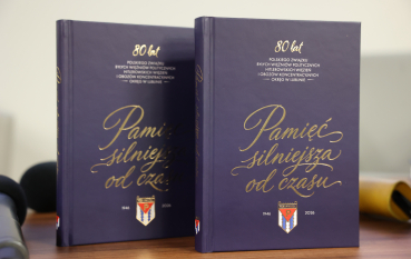 Dwie książki, napis: Pamięć silniejsza od czasu. 