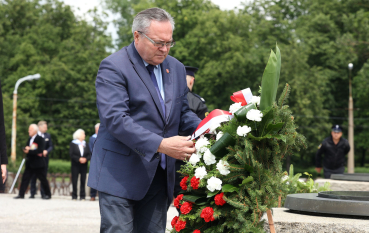 Mężczyzna w garniturze podczas składania wieńca 