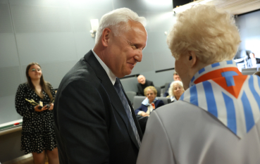 Mężczyzna w garniturze rozmawia ze starszą kobietą 