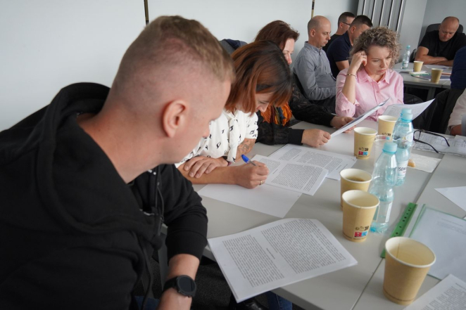 Grupa dorosłych pracująca z materiałem źródłowym.