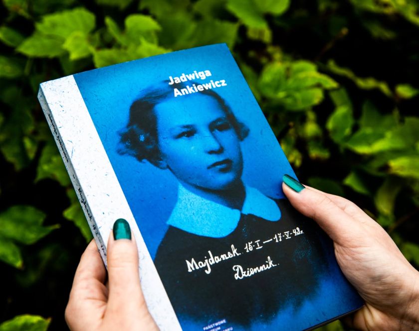 Książka Dziennik Jadwigi Ankiewicz z niebieską okładką na tle zielonych liści.